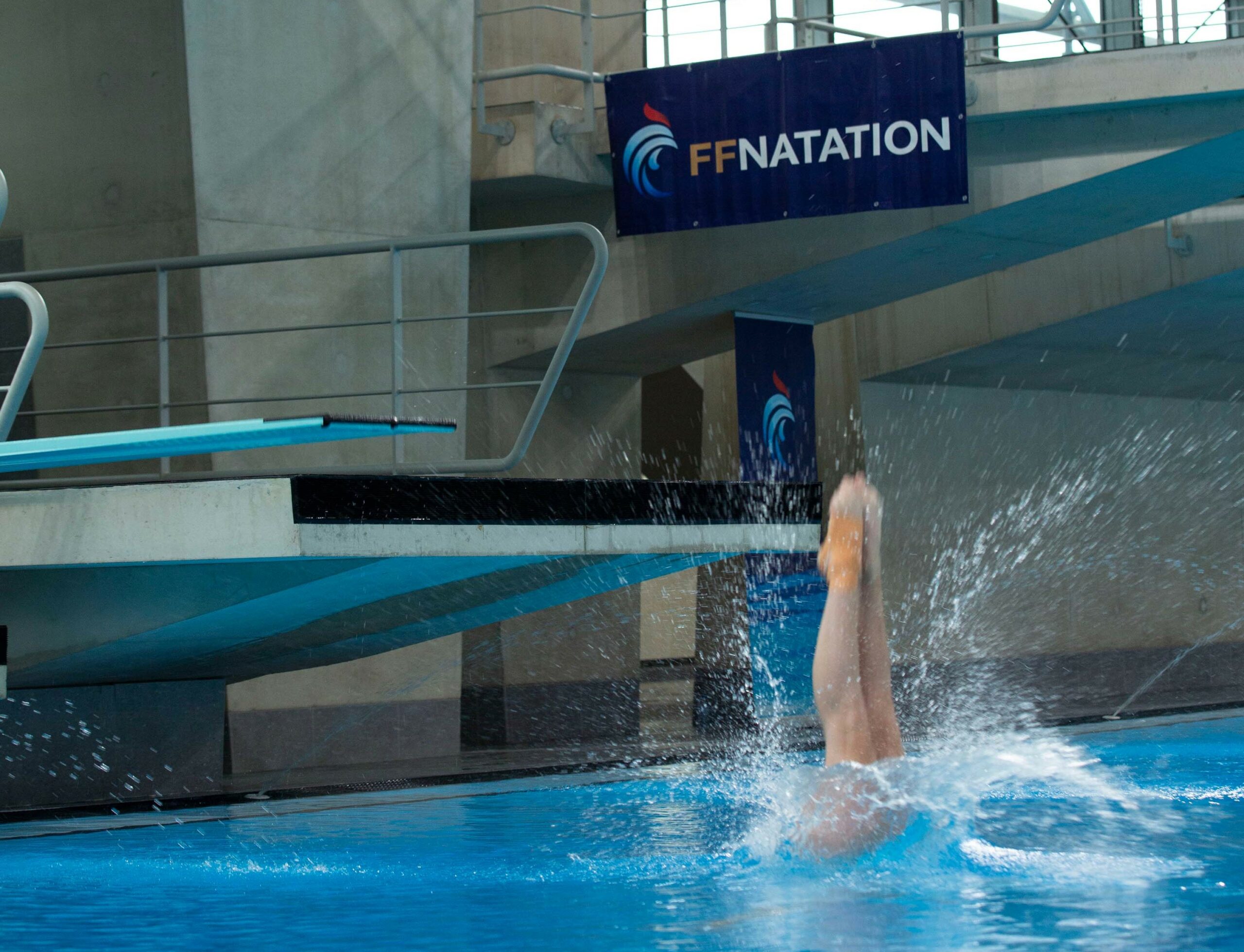 Plongeuse entrant dans l'eau depuis le Tremplin de 1m.